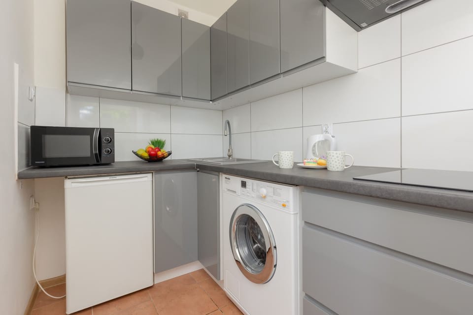 A fully equipped kitchenette featuring modern appliances, including a washing machine.



