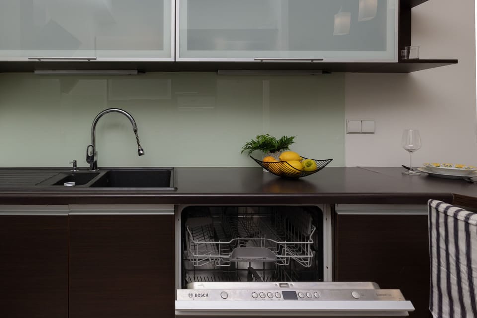 A functional kitchen sink area with dark cabinetry and clean, modern lines.

