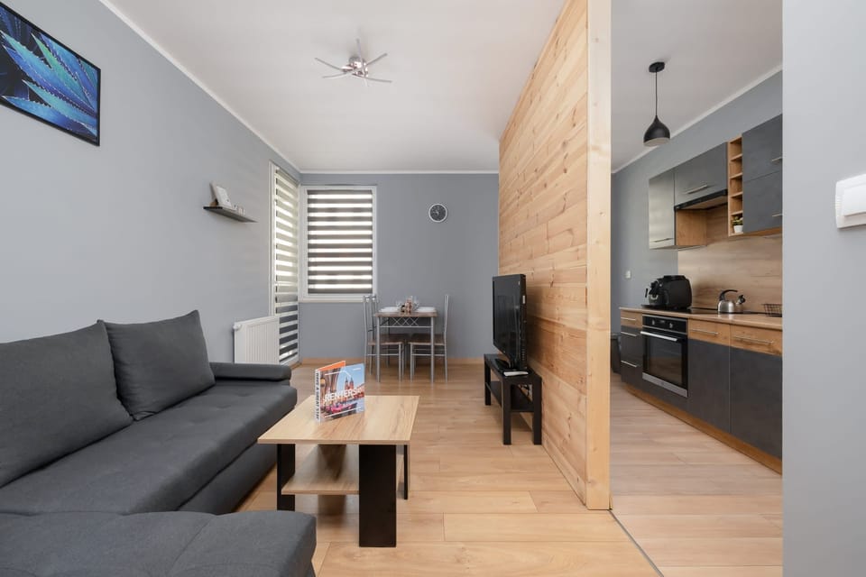 A cozy living room with a gray sofa, coffee table, and warm wooden accents creating a modern ambiance.

