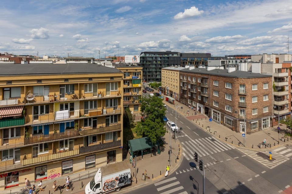 A vibrant urban street view featuring charming buildings, a busy intersection, and lively surroundings.
