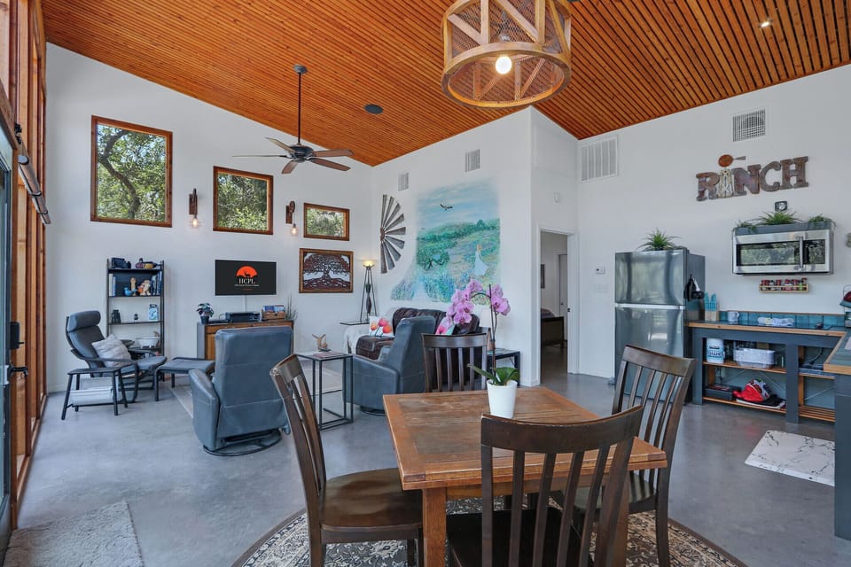 View showing the open concept floor plan of the cabin.  The entrance to the bedroom can be seen to the left of the refrigerator.