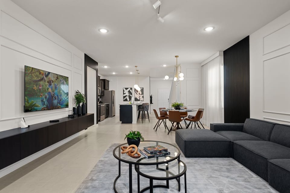 Spacious living room with modern decor and large smart TV.