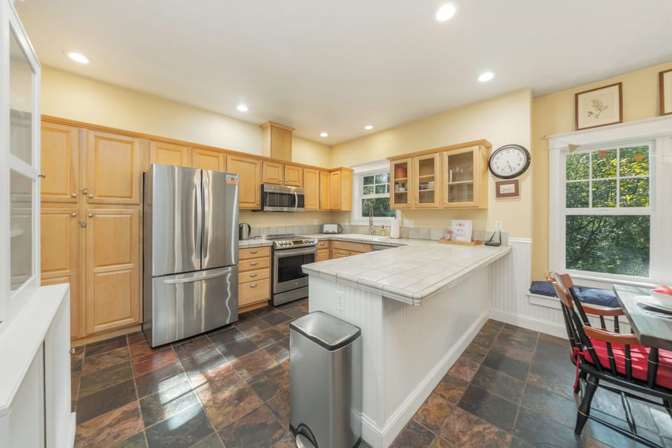 Fully equipped kitchen open to the dining room with wood burning fireplace.