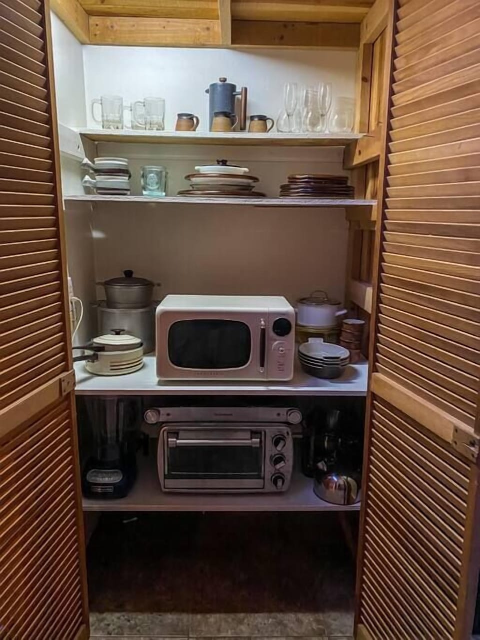 Artfully curated collection of vintage cookware, tableware, artisanal drink ware, and plenty of appliances including: 2 burner hot plate, large capacity toaster oven (big enough for small casseroles), microwave, and blender. 