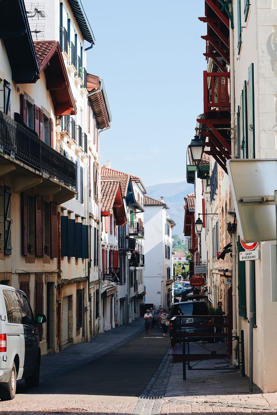 A sun-drenched cobbled street lined with traditional Basque facades winds through the heart of Saint-Jean-de-Luz's charming old town.