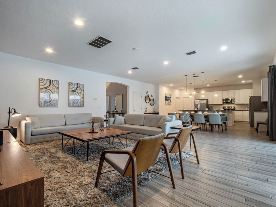 - Open-concept living and dining with stylish decor  
- Large sofas and modern chairs provide ample seating  
- Connected layout to kitchen makes gatherings easy