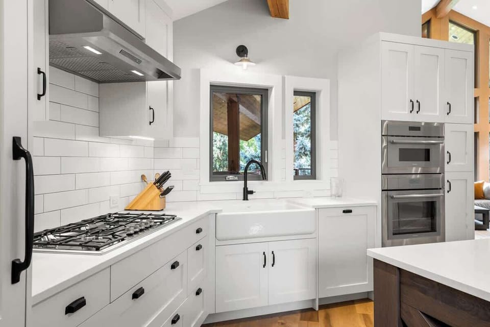 - Modern kitchen with white cabinets and stainless steel finishes  
- Farmhouse sink and subway tiles create a clean timeless look  
- Fully equipped for family meals and cozy nights in  