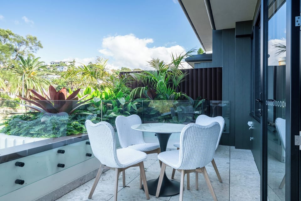 The other end of the main balcony with outdoor seating and a door tleading from the kitchen.