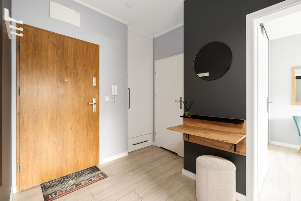 An entryway featuring a wooden door, coat hooks, and a functional yet stylish layout.

