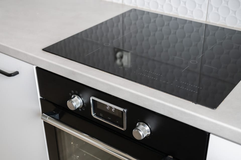 A close-up of a sleek black stove with precise controls for easy cooking.

