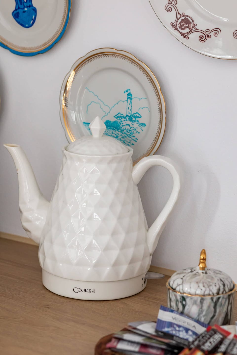 A close-up of a decorative teapot and a tray with colorful items, adding a whimsical touch.

