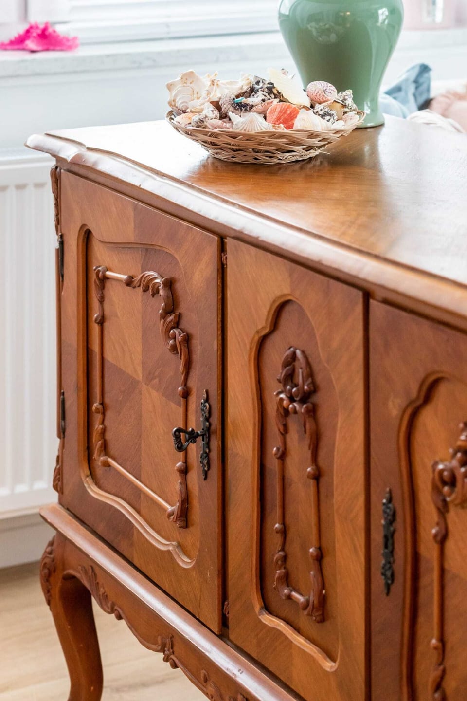 A close-up of a vintage wooden sideboard, adding character and charm to the space.

