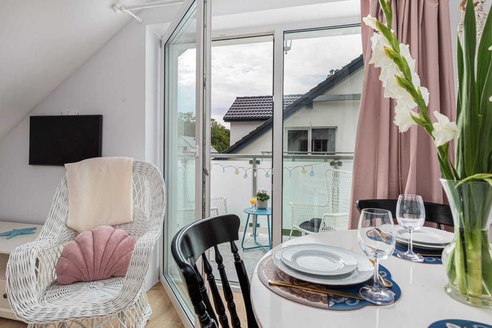 A beautifully set dining table with floral decor, elegant tableware, and a cozy seating area nearby.








