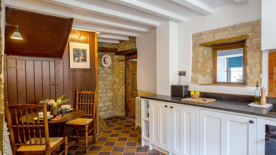 This beautifully finished room features terracotta and black quarry stone tiles, exposed stone walls and an original fireplace.
