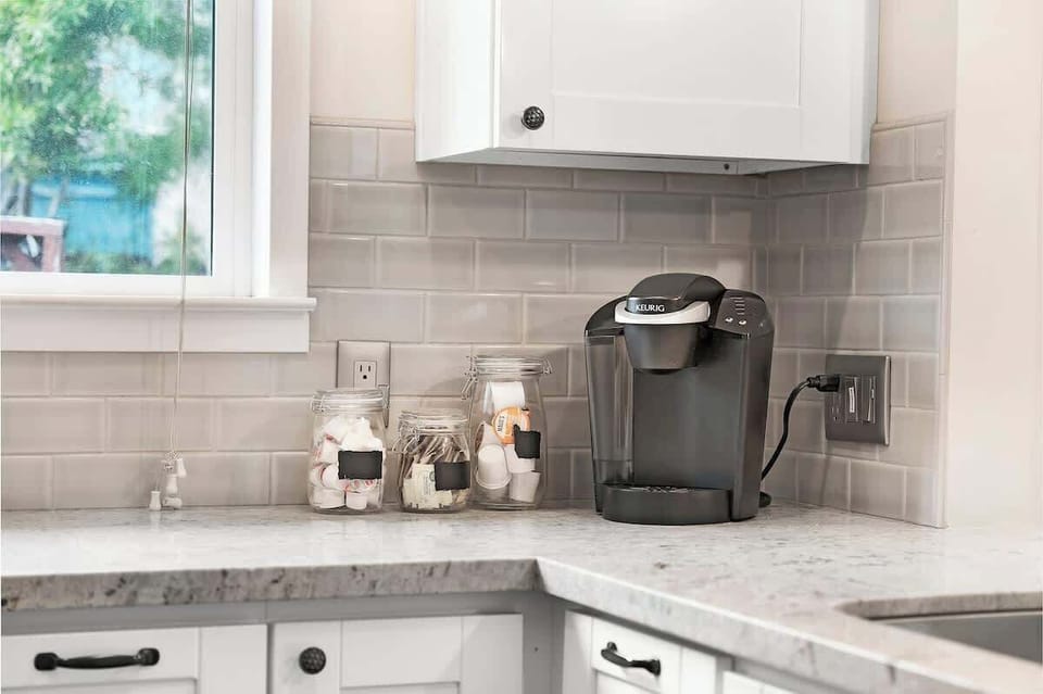 Coffee bar with Keurig, mugs, and counter space—brew before heading to Balboa Park museums nearby