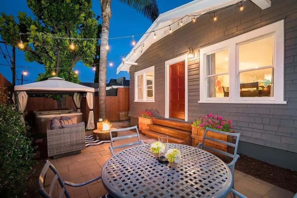 Cozy patio with string lights and bistro table beside this Craftsman bungalow in North Park