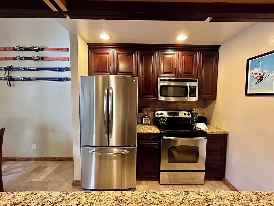Stainless steel fridge, oven and microwave in kitchen.