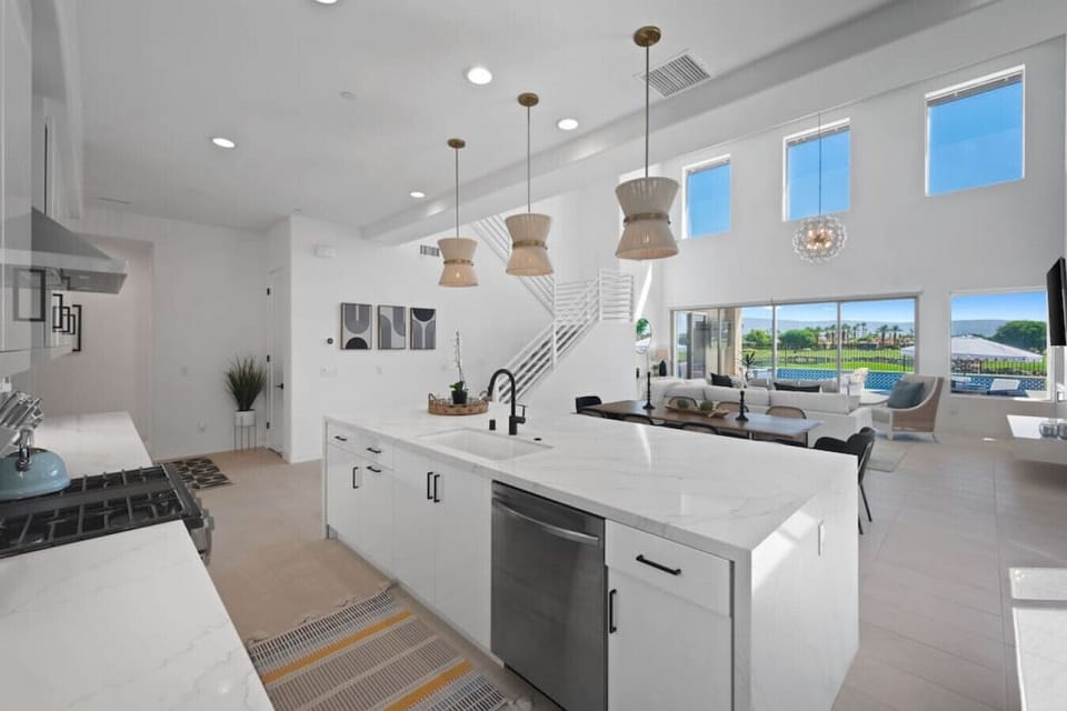 Bright kitchen w/ large island, pendant lighting & windows filling the space w/ light