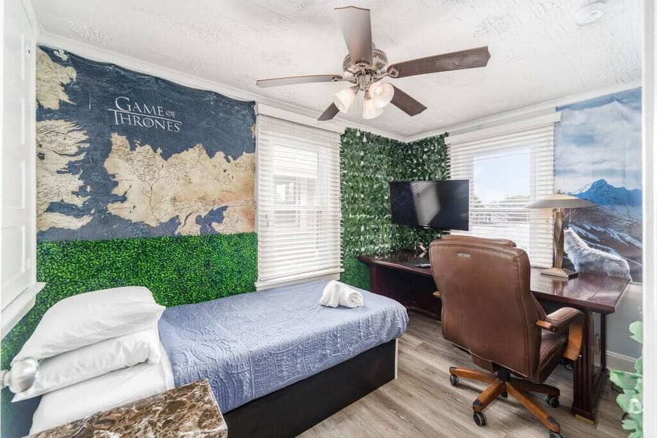 The rear bedroom includes a twin smart/adjustable bed, a smart TV, and an office workstation.