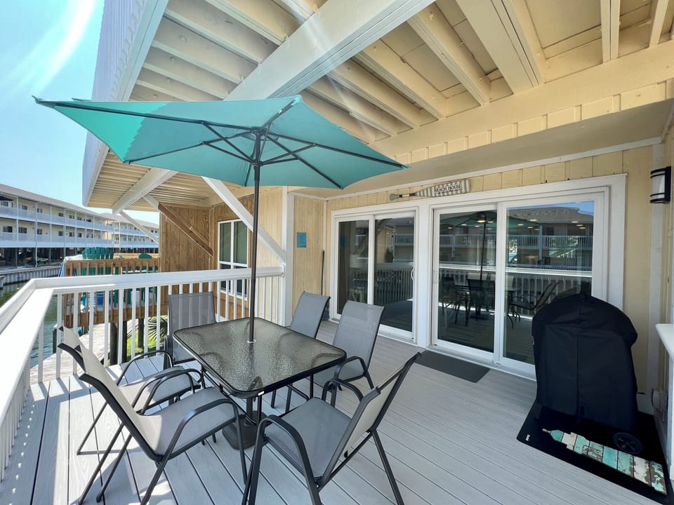 Your covered balcony offers shaded dining with a BBQ grill, perfect for enjoying outdoor meals while staying cool.