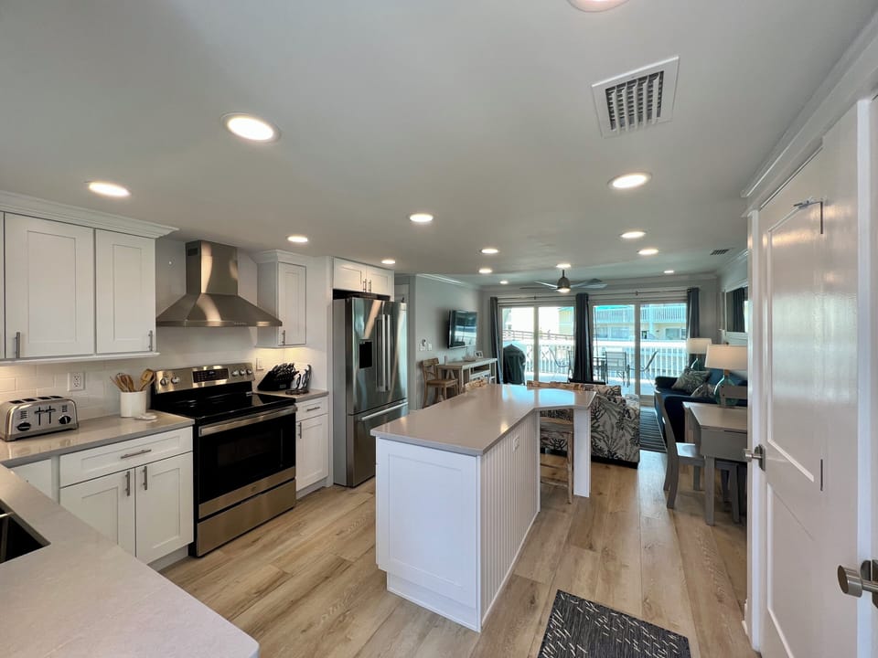 Your open-concept retreat features a fully equipped kitchen with modern appliances, spacious island, and seamless flow into the comfortable living area.