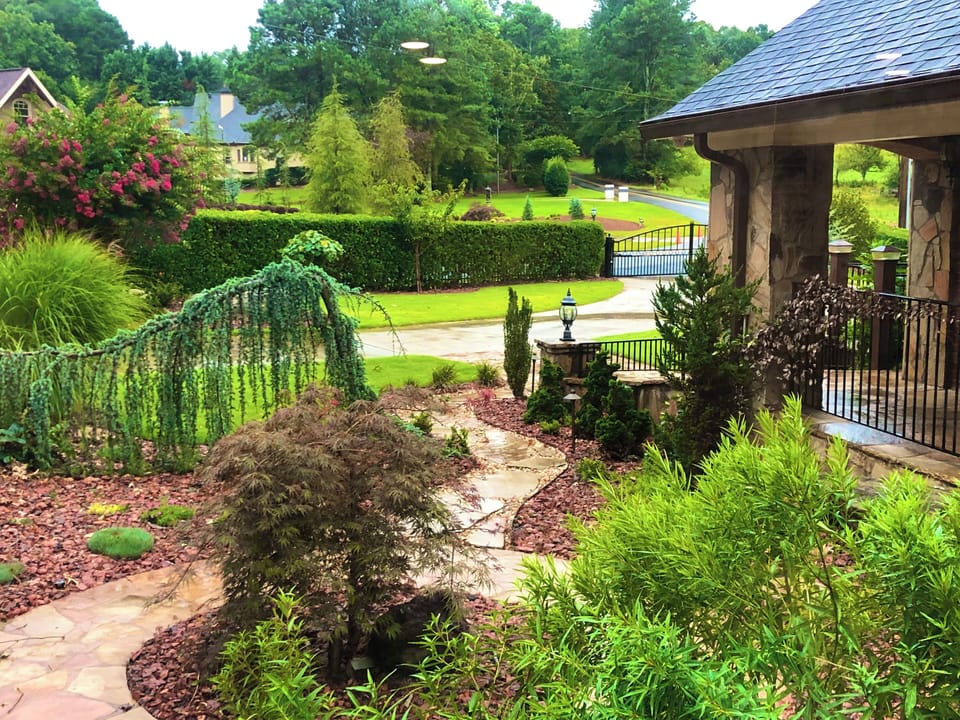 Richly manicured front garden and landscape, and upscale neighborhood scenery.