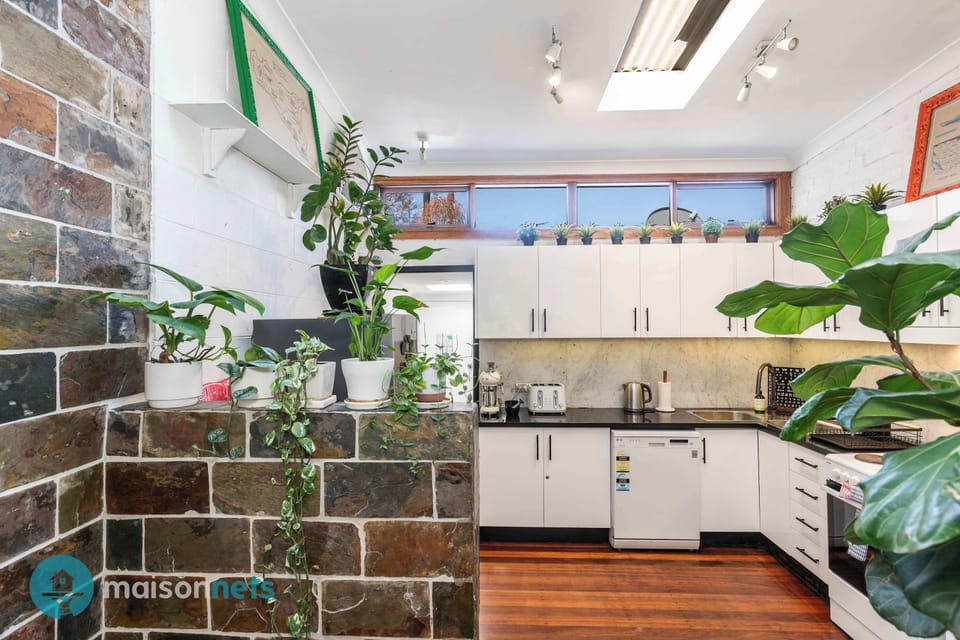 Large kitchen filled with indoor plants and high line window