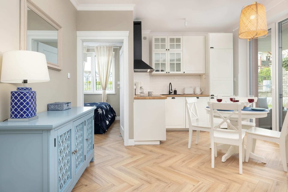 A dining space with a round table, bright white cabinets, and a touch of blue decor.

