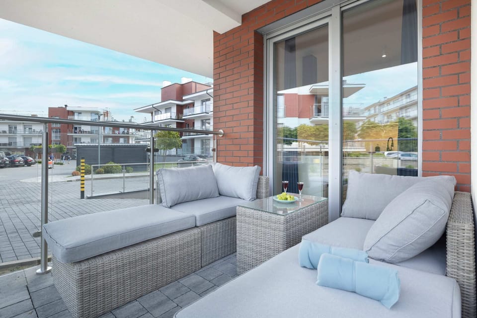 A balcony with wicker furniture and plush cushions, perfect for outdoor relaxation.


