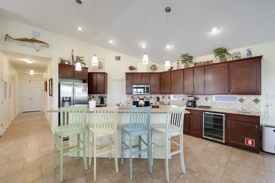 Spacious coastal kitchen with granite countertops, bar seating, and an open layout perfect for gathering.