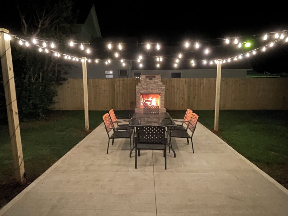 Stone fireplace on the patio featuring a pizza oven & a large dining space