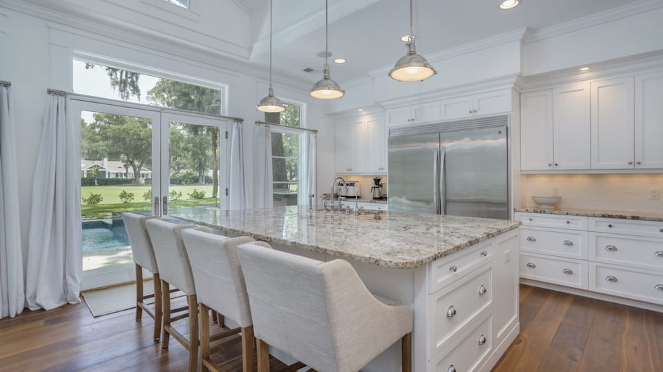 Pendant lighting brighten the space, while the wide layout and double-door refrigerator create an ideal environment for  gathering with ease.