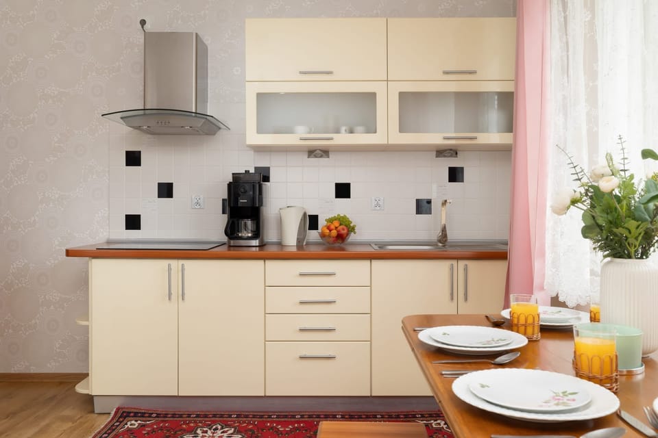 Functional bright kitchen with table with crockery.