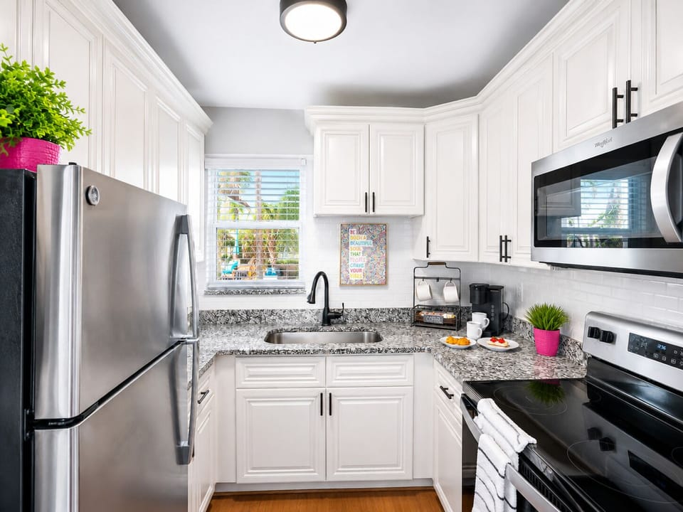 Cook your favorite meals with ease in the modern kitchen featuring stainless steel appliances, granite countertops, cookware, dishes, and all the essentials you'll need.