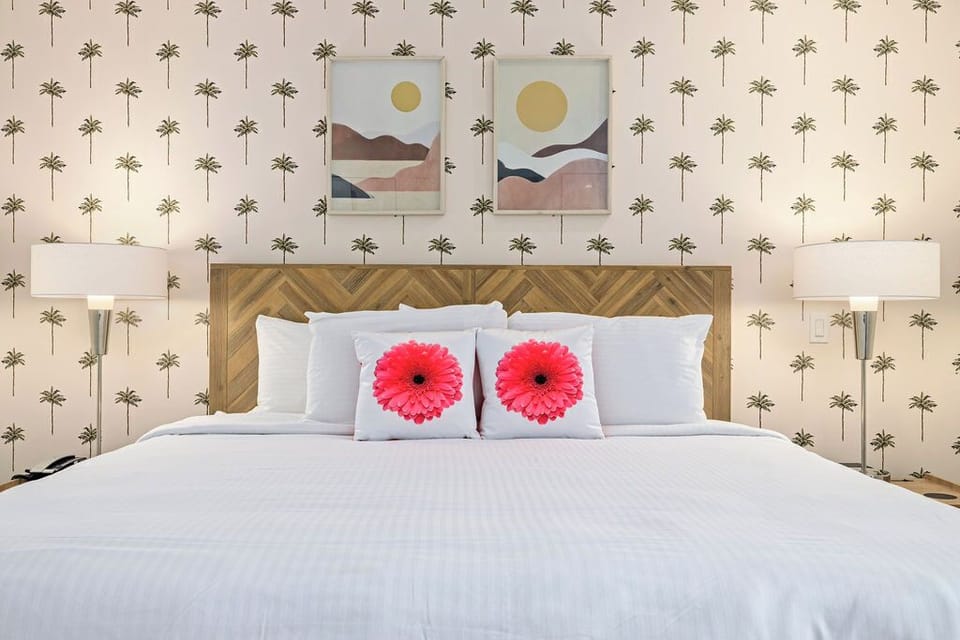 Sink into crisp, cloud-like linens on your plush bed, styled with cheerful accents and framed by tropical palm wallpaper and dreamy desert artwork.