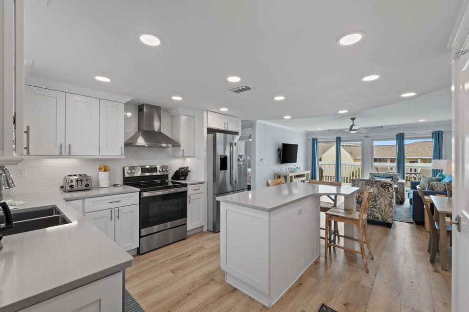 Bright, open-concept living with a chef-ready kitchen flowing into your sunny living space—perfect for family gatherings or morning coffee with coastal views through expansive windows.