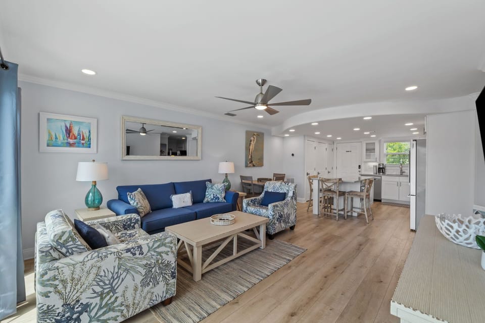 Unwind in your bright, open-concept space where coastal blues meet natural wood tones. The plush seating invites relaxation while you're steps from your fully-equipped kitchen and dining area.