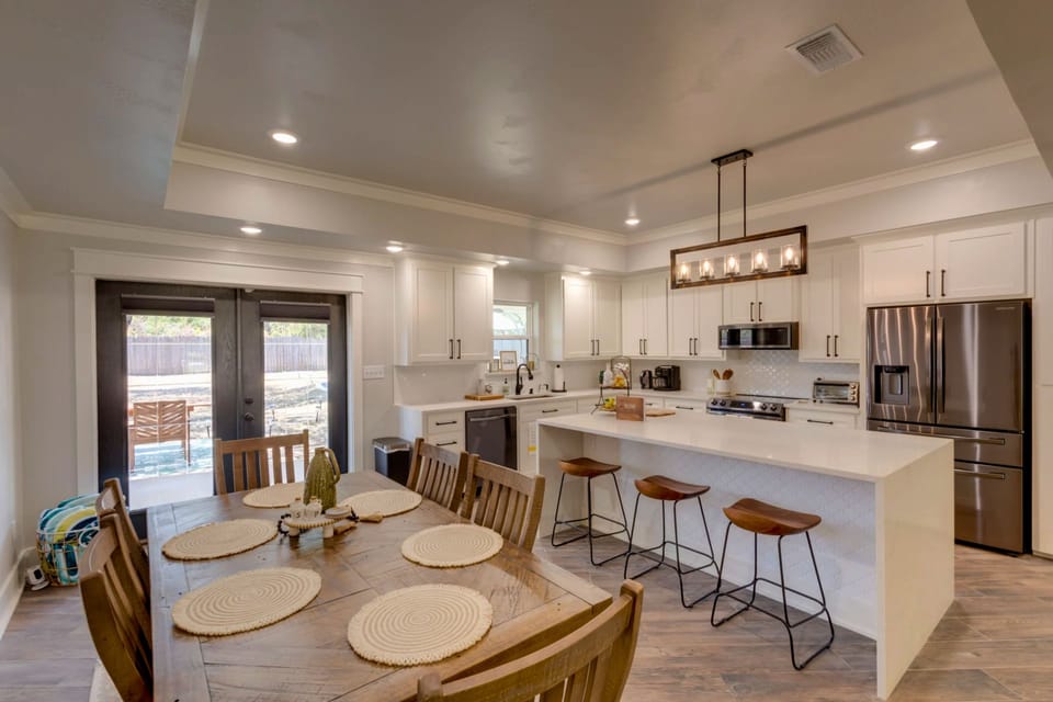 Open kitchen with large island, seating, and dining area for gathering