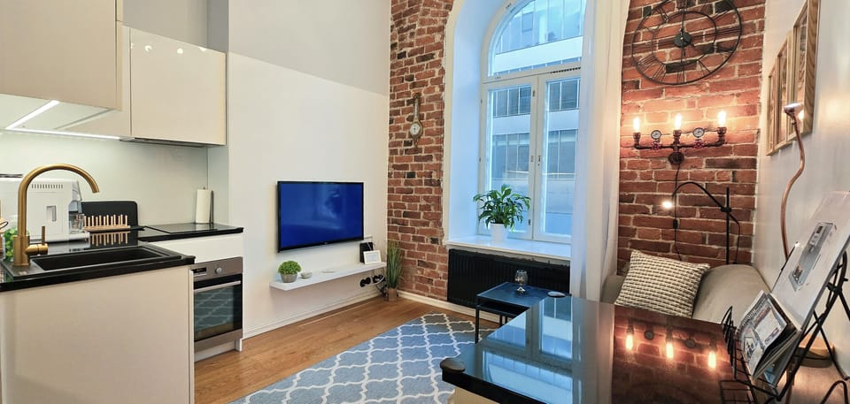 Bright & airy: high ceilings, arched window, cozy brick lounge.