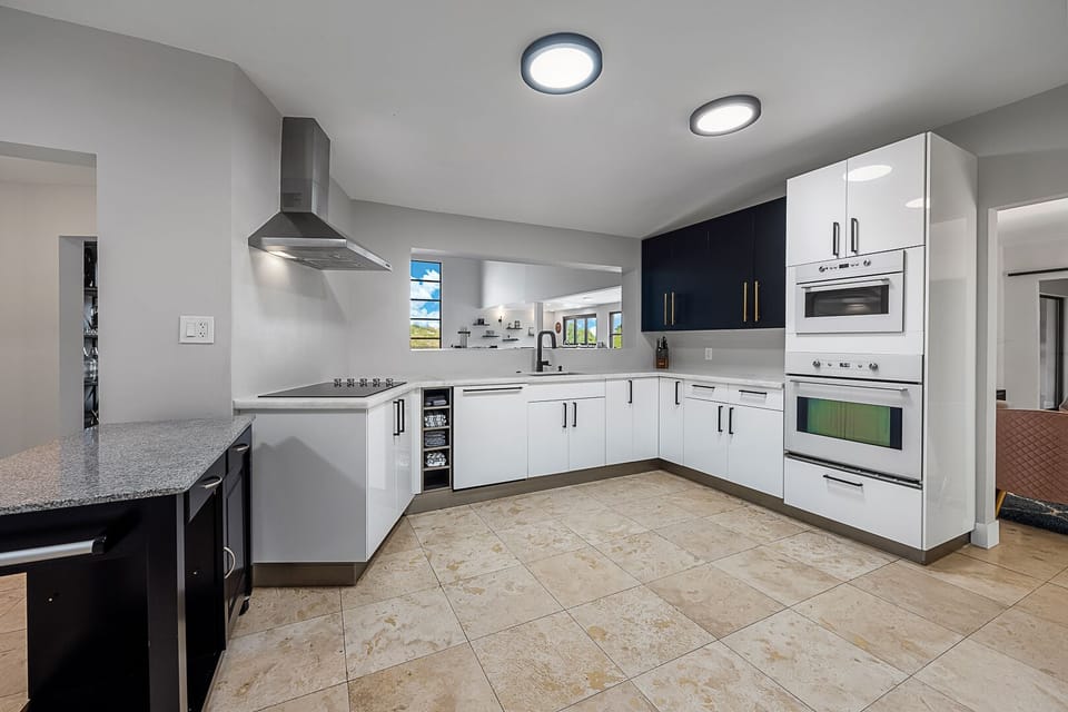 Modern kitchen w/ glass cooktop, built in oven, oversized fridge, & bar counter