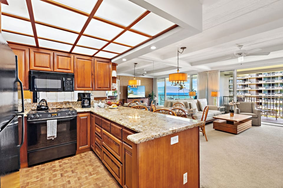 Bright and inviting open-concept kitchen featuring cabinetry, sleek countertops, and a spacious island that flows seamlessly into the living and dining areas. Perfect for entertaining or relaxing in comfort.