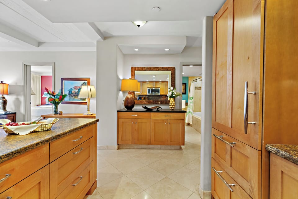 Step into your island retreat through a welcoming entryway that leads to a beautifully appointed kitchen. Featuring spacious countertops, ample storage, and an open layout, this residence offers all the comforts of home in the heart of Kāʻanapali.
