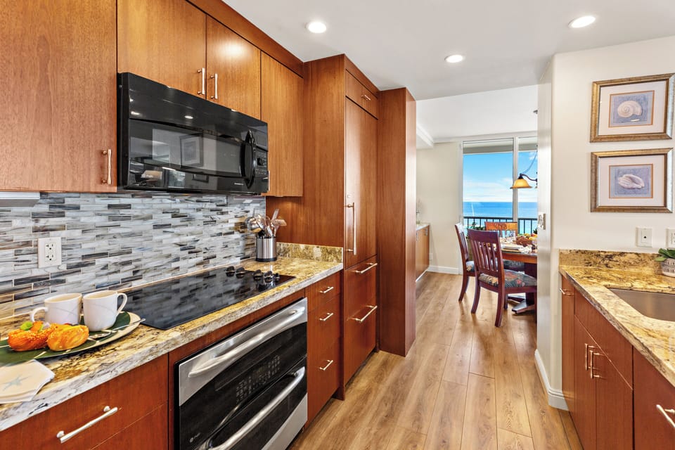 Elegant kitchen featuring stone countertops, warm wood finishes, and stainless appliances. Bright and well-appointed for everyday living.