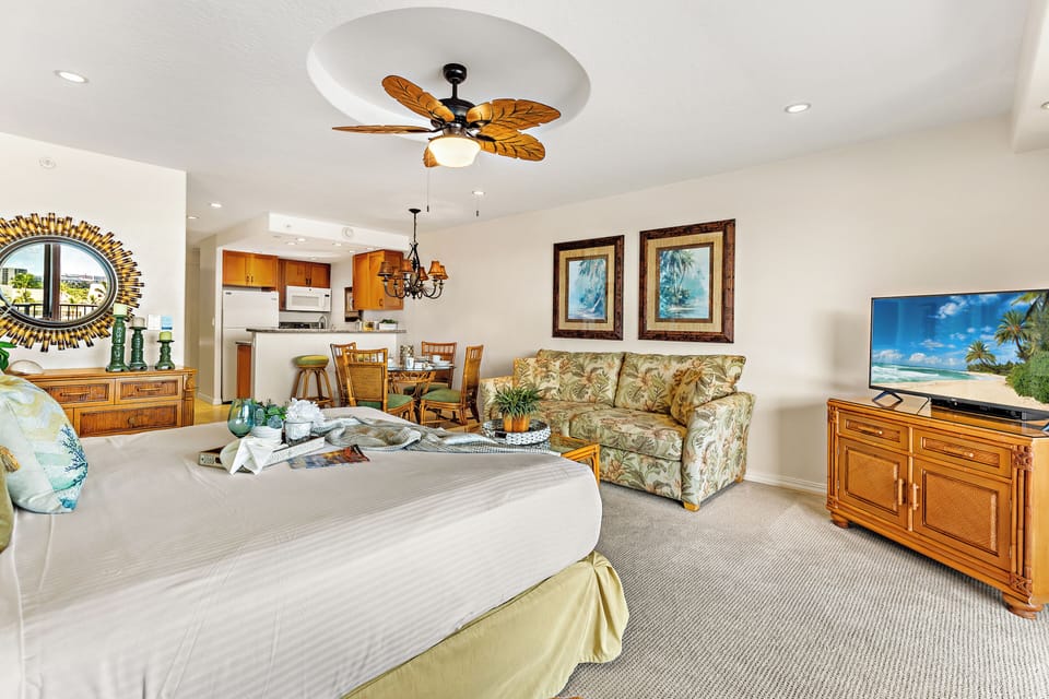 Bright and inviting studio living space featuring stylish island décor, plenty of natural light, and a cozy sofa sleeper for extra guests, all paired with relaxing lanai views.