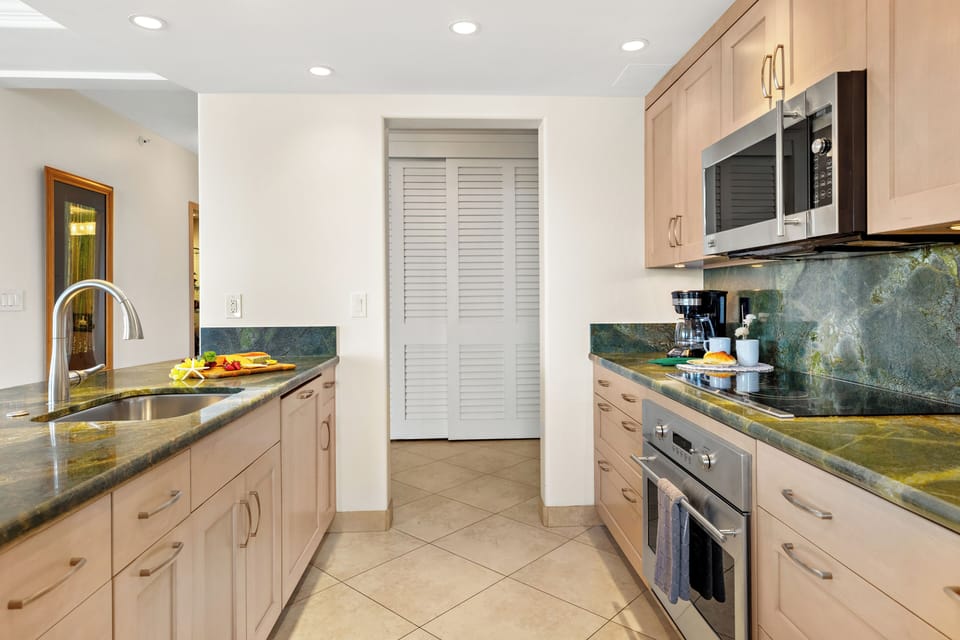Contemporary kitchen with rich wood cabinetry, refined finishes, and a spacious island designed for effortless dining and entertaining in a relaxed coastal setting