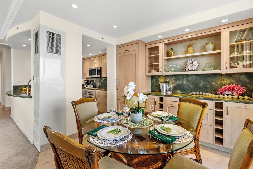 An inviting dining space where island elegance meets breathtaking ocean views. Gather around the beautifully set table, surrounded by warm textures, coastal-inspired décor, and soft ambient lighting.