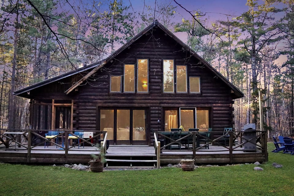 Surrounded by nature, the cabin’s backyard offers a private deck, dining area, and serene views through the windows.