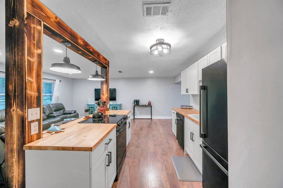 Fully Equipped Kitchen Offers Butcher Block Style Countertops, Sleek White Cabinets and Updated Appliances