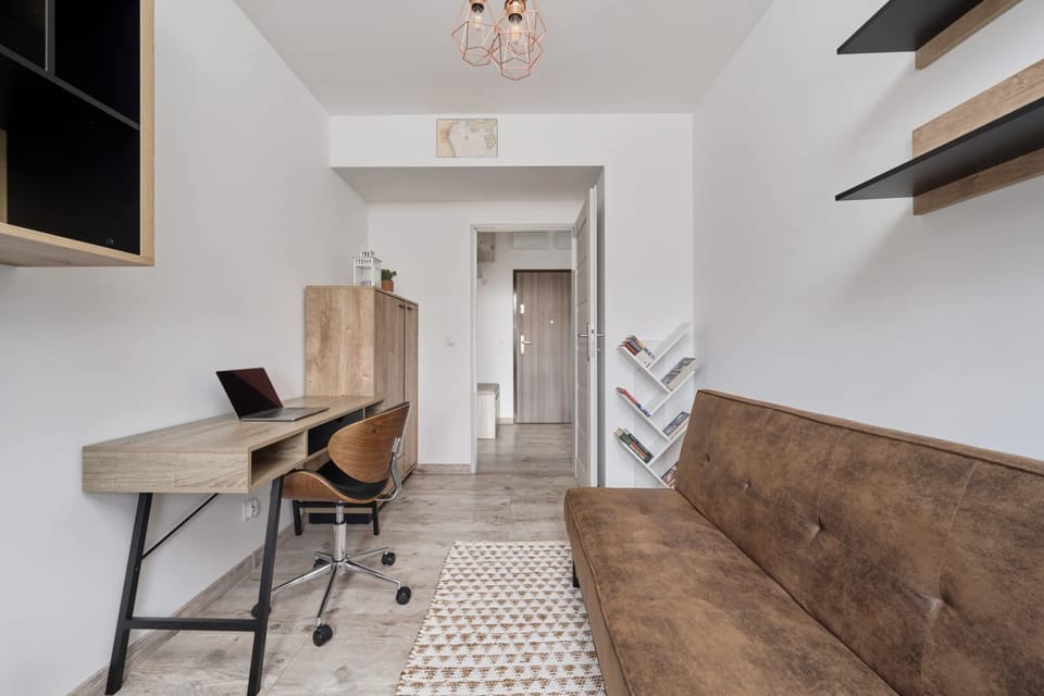 The stylish bedroom includes a comfortable sofa bed and an armchair.