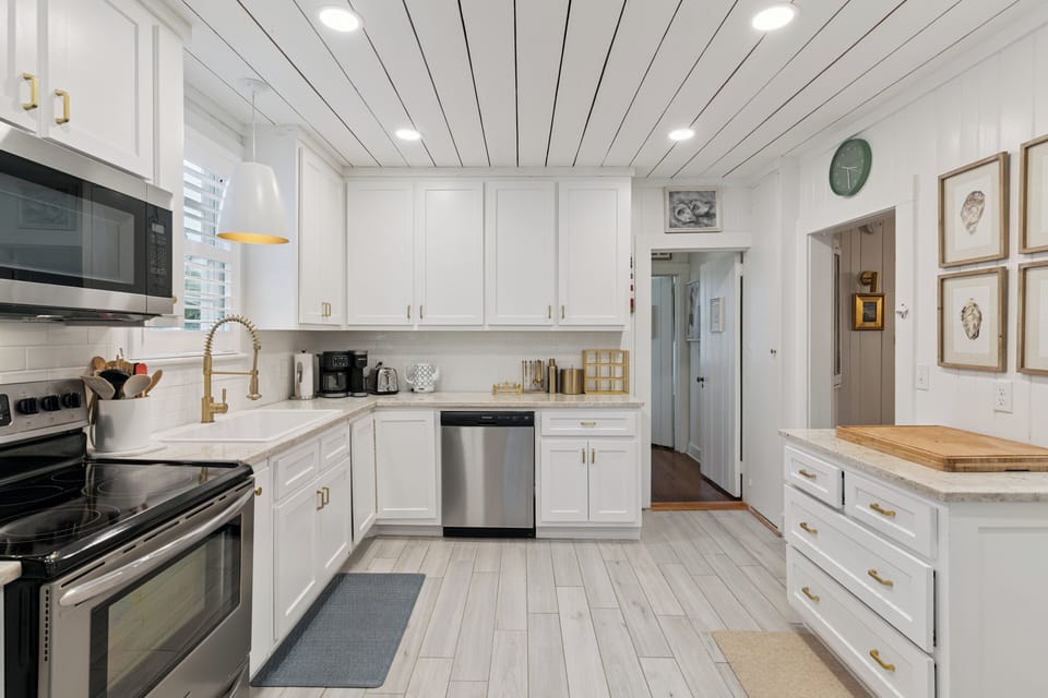 Your fully-equipped gourmet kitchen features stainless appliances, a warming wood island, and stylish white cabinetry—perfect for whipping up meals together during your stay.